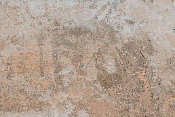 Plastered weathered wall with detailed texture. Beige grunge background. A concrete surface with damages. - Foto, imagen