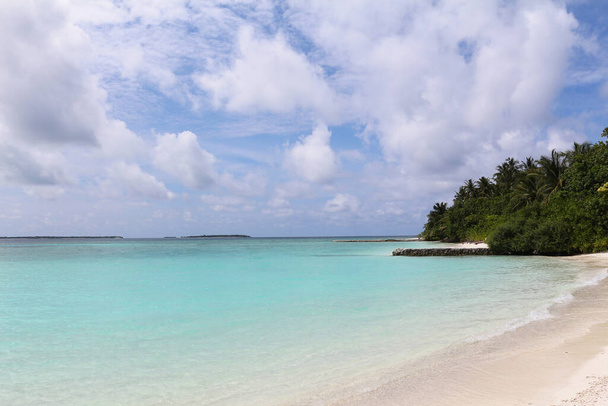 Maldives, a beach with the white sand near the turquoise ocean. Summer vacation on a paradise tropical island. - Φωτογραφία, εικόνα