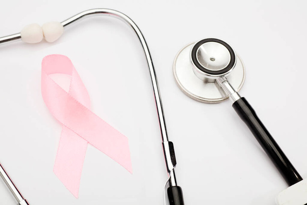 розовая лента рака, стетоскоп, белый фон, международный символ информированности о раке молочной железы и моральной поддержки женщин. Изолированный фон, - Фото, изображение