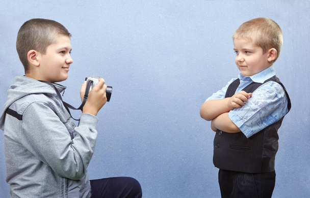 Chłopiec z kamerą fotografuje brata. - Zdjęcie, obraz
