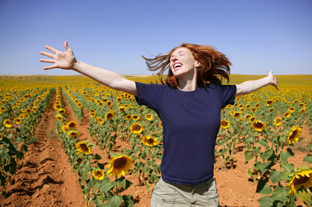 κοκκινομάλλα ευτυχισμένη γυναίκα στον τομέα ηλιοτρόπια - Φωτογραφία, εικόνα