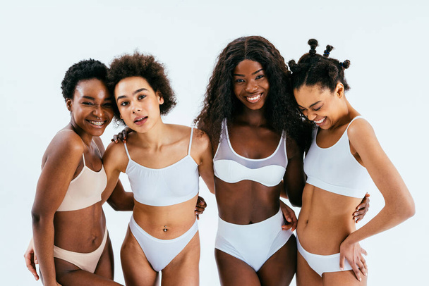 Beauty portrait of beautiful black women wearing lingerie underwear - Pretty african young women posing in studio, concepts about beauty, cosmetology and diversity - Фото, изображение