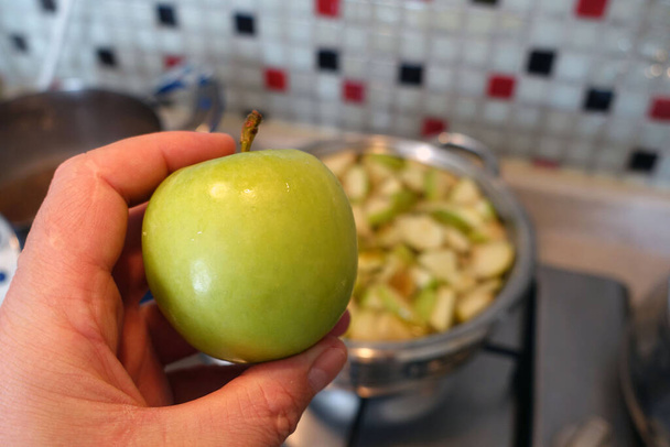 φτιάχνοντας κομπόστα μήλου, ψιλοκομμένα κομμάτια μήλου βρασμένα σε κατσαρόλα, φτιάχνοντας σπιτικό χυμό μήλου, - Φωτογραφία, εικόνα