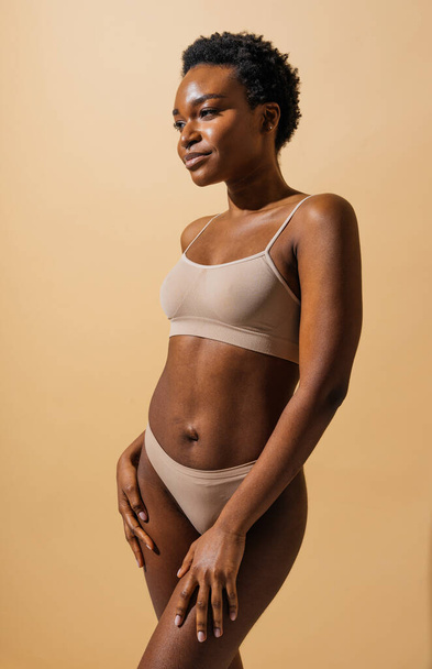 Beauty portrait of beautiful black woman wearing lingerie underwear - Pretty african young woman posing in studio, concepts about beauty, cosmetology and diversity - 写真・画像