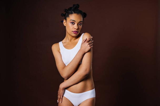 Beauty portrait of beautiful black woman wearing lingerie underwear - Pretty african young woman posing in studio, concepts about beauty, cosmetology and diversity - Fotó, kép