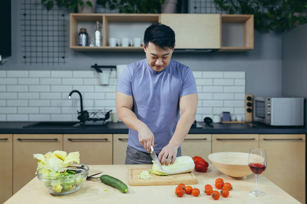 Asian vegetarian chops vegetables at home, Asian prepares salad for dinner - Foto, Bild