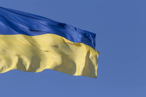 close up of waved Ukrainian flag against blue sky - Foto, Imagen