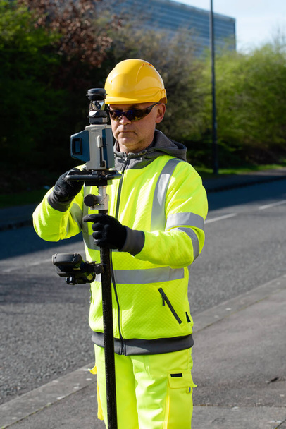 Site engineer checking levels of the road using autolevel - Photo, Image