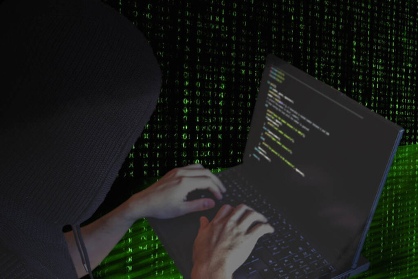 Концепція темної веб-кібервійни. Хакер з капюшоном використовує ноутбук для організації масового нападу на державні сервери
 - Фото, зображення