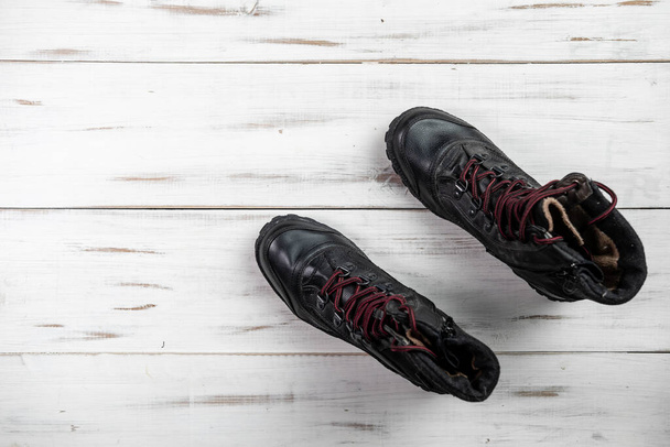 Black comfortable casual women's boots with laces on a light wooden background. - Foto, Imagem