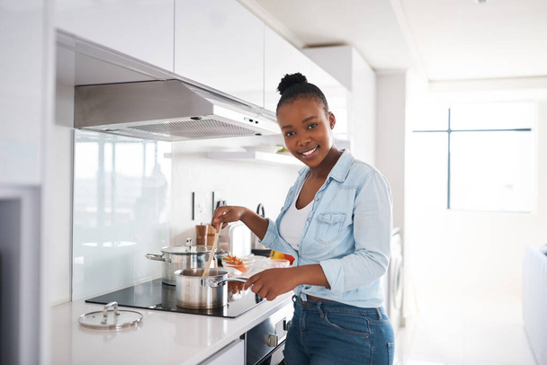 Eine herzhafte Mahlzeit macht ein Haus zu einem Zuhause. Aufnahme einer schönen jungen Frau, die zu Hause in ihrer Küche kocht. - Foto, Bild
