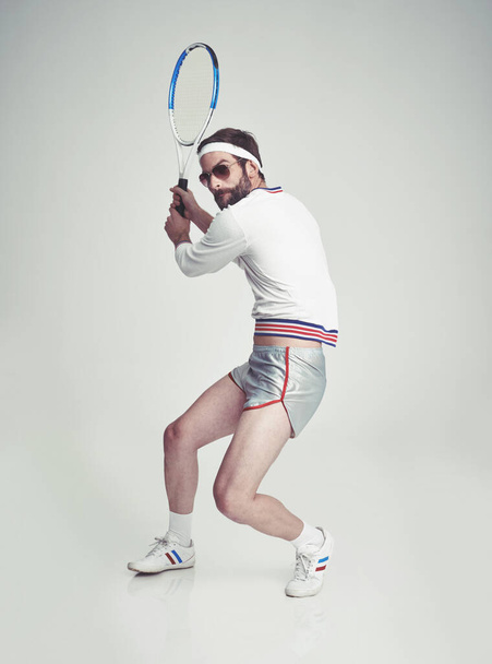 レトロなフィットネス。テニス用具を着たスタジオの若い男. - 写真・画像
