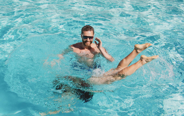 Summer pool resort. Couple in swimming pool. Active summer leisure. - Fotó, kép