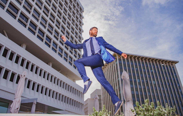 Businessman running. Business man in formal wear while running and jump in the city on a background of building. Late for work concept. - Valokuva, kuva