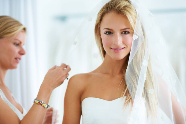 Mettere i tocchi finali. Una giovane donna che prova abiti da sposa in una boutique nuziale. - Foto, immagini