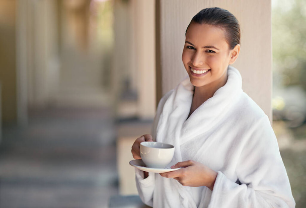 Today its all about me. Shot of a young woman drinking a cup of coffee at the day spa. - Фото, изображение