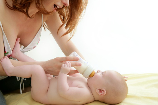 Nude blond baby playing mother hands - Foto, afbeelding