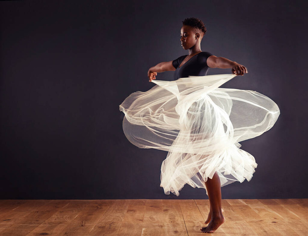 Freedom of expression. Young female contemporary dancer using a soft white white skirt for dramatic effect. - Foto, Imagem