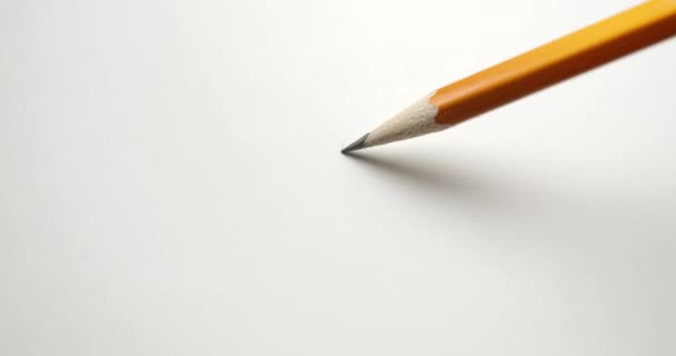 Teken een golvende lijn over papier met een geel potlood. - Video