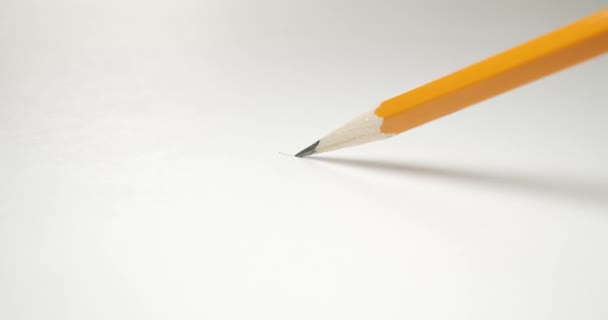 Drawing a wavy line across paper with a yellow pencil. - Footage, Video