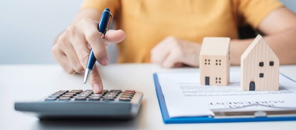 Woman using calculator during signing home contract documents. Contract agreement, real estate,  buy and sale and insurance concepts - Photo, Image