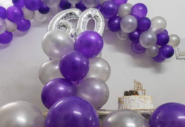 60-te dekoracje urodzinowe z kolorowymi balonami i białymi ciastkami pod różnym kątem - Zdjęcie, obraz