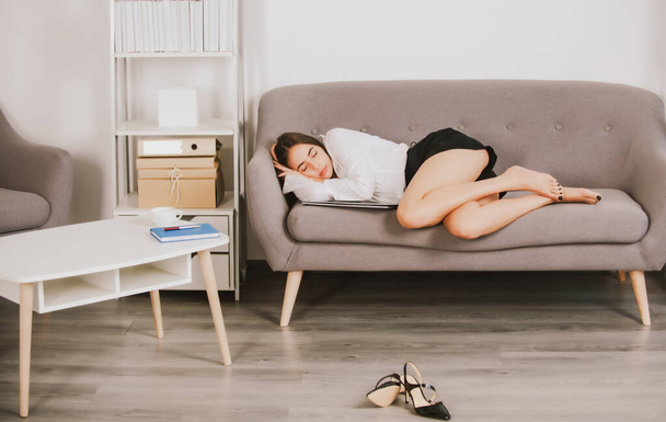 Tired business woman sleeping at office. Young Secretary sleep on sofa. - Foto, Bild