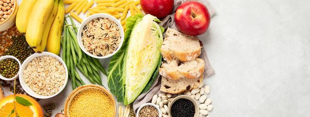 Selection of good carbohydrates sources - vegetables, fruits, grains, legumes, nuts and seeds on white background, top view, panorama with copy space. - Foto, imagen