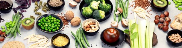 Food sources of plant based diet. Healthy diet with legumes, dried fruit, seeds, nuts and vegetables. Foods high in protein, antioxidants, vitamins and fiber. Top view, flat lay, panorama. - Fotó, kép