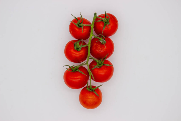 Cherry tomatoes on branch stand on white background. Isolated image - 写真・画像