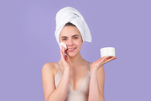 Beauty woman. Cosmetic cream on woman face with clean soft skin. Body care. Woman with towel applying cream on skin. Body care and spa salon concept. Spa girl. Beautiful young woman with perfect skin. - Photo, image