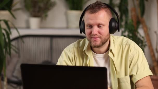 Man wearing headphones, study online education training, male student learning language, watching online course, e-learning education, writing notes, - Footage, Video