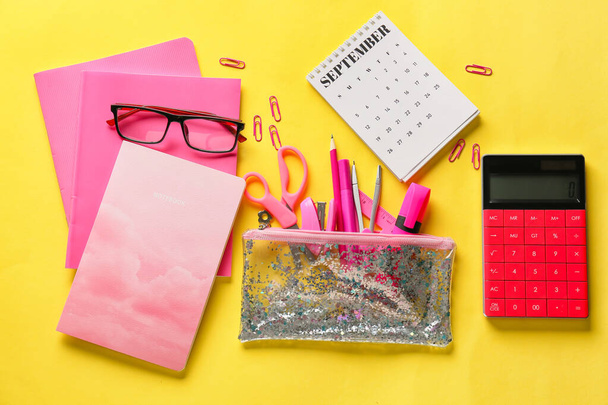 Composition with different stationery, calendar and eyeglasses on yellow background - Photo, Image