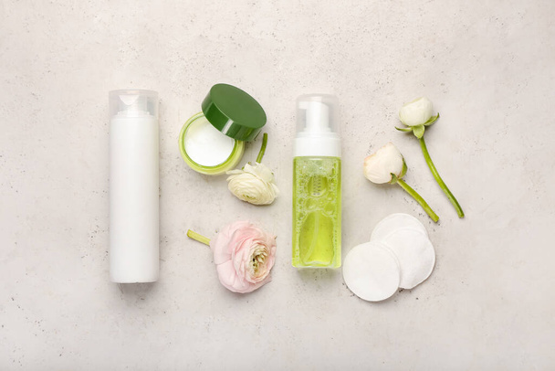 Composition with cosmetic products, cotton pads and ranunculus flowers on light background - Photo, Image