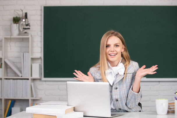 Portrait of young female college student studying in classroom on class on blackboard background. - Foto, Imagen