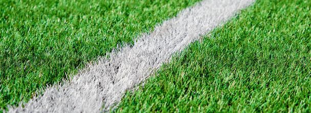 Teil des Fußball- oder Fußballfeldes aus nächster Nähe, künstlicher grüner Rasen mit weißen Randstreifen, Astroturf im Stadion für Spiele - Foto, Bild