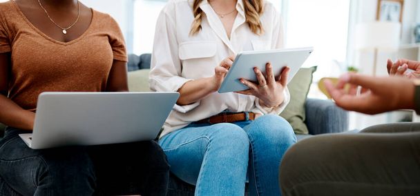 Digitale notities maken zoals de presentatie gaat. Close-up van twee onherkenbare zakenvrouwen die een laptop en digitale tablet gebruiken tijdens een vergadering in een kantoor. - Foto, afbeelding