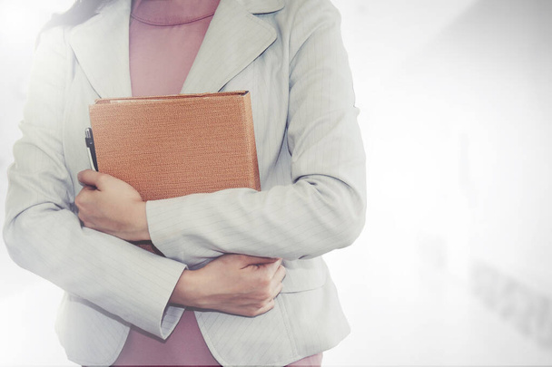 Geschäftsfrau im weißen Anzug, in der Hand eine Urkunde für die Gründung einer Geschäftsstelle, der Stolz eines Unternehmens. - Foto, Bild