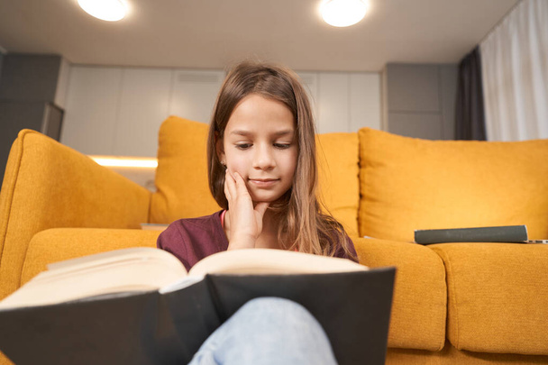 Adolescente está sentado con un libro abierto y leerlo - Foto, Imagen