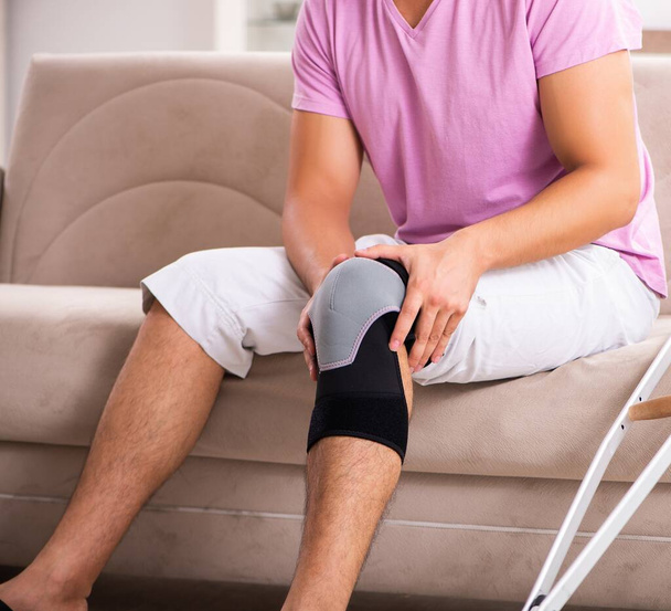 Il giovane con il ginocchio ferito che si riprende a casa - Foto, immagini
