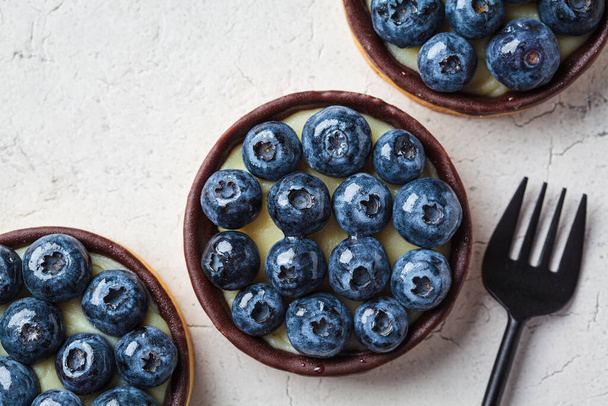Tartlet with blueberries, chocolate and cream cheese, top view. Vegan dessert concept. - Fotografie, Obrázek