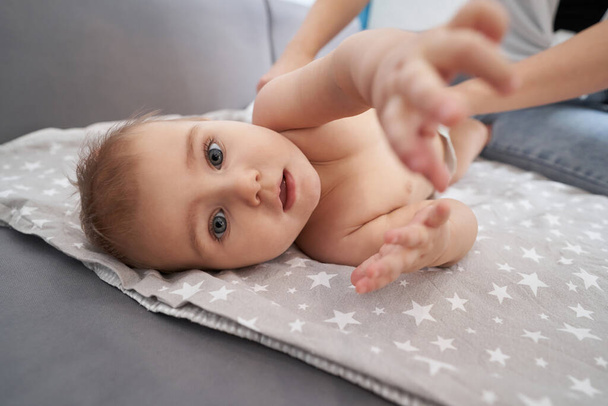 Interested baby stretching out its hand to camera - Valokuva, kuva