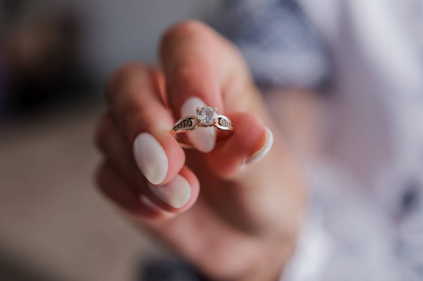 Gold ring with a stone in the hands of the bride - 写真・画像