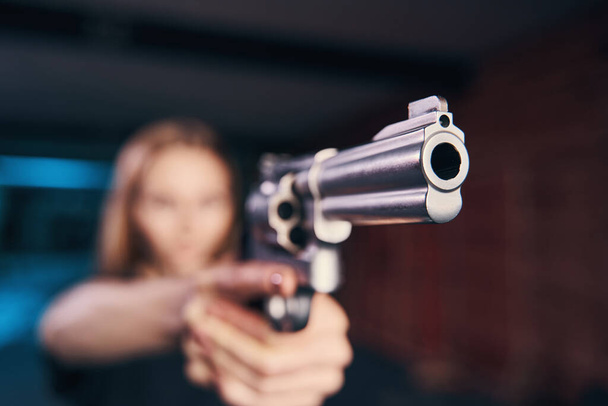 Опытная женщина-стрелок держит пистолет обеими руками - Фото, изображение
