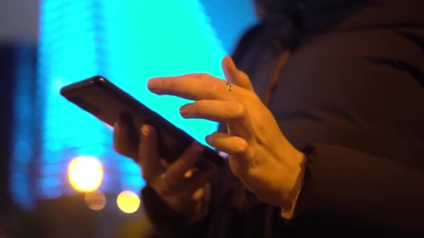Een vrouw surfen op het internet op een mobiele telefoon in haar vrije tijd buiten. - Video
