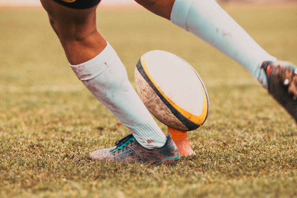 jugador de rugby se prepara para patear la pelota ovalada durante el juego
 - Foto, imagen