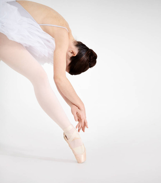 Nothing but elegance. Dedicated young ballerina dancing en pointe against a white background. - 写真・画像