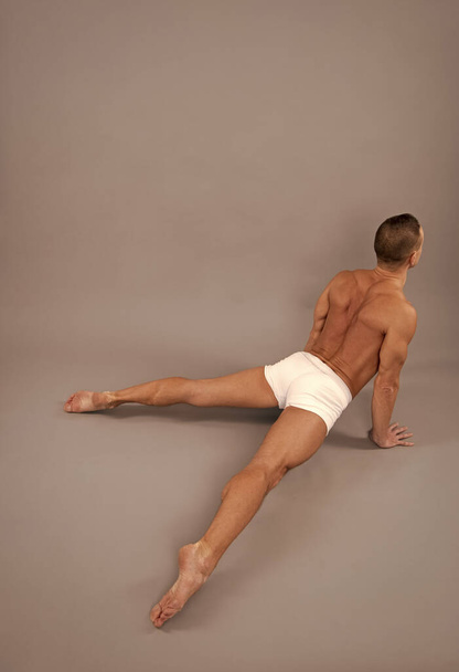 Athletic man do cobra pose. Gymnastic routine. Back bending asana in hatha yoga. Gymnastic activity - Foto, imagen