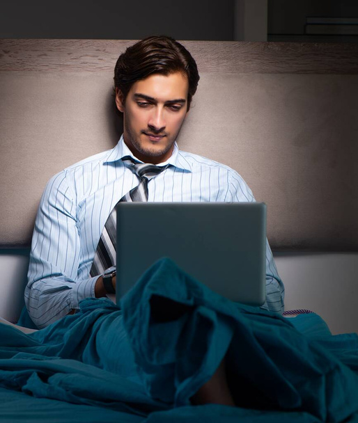 Уставший бизнесмен работает сверхурочно по ночам дома
 - Фото, изображение