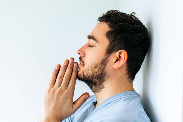 side view of a bearded man going through difficult period in life, praying. - 写真・画像